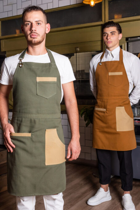 Versatile canvas apron in Olive Green and Camel, combining style and functionality. Features three functional pockets and an adjustable neck strap with a bronze hook for a customizable fit. Perfect for professionals and creatives in various fields. Elevate your workwear with this uniquely designed, all-day comfortable apron.