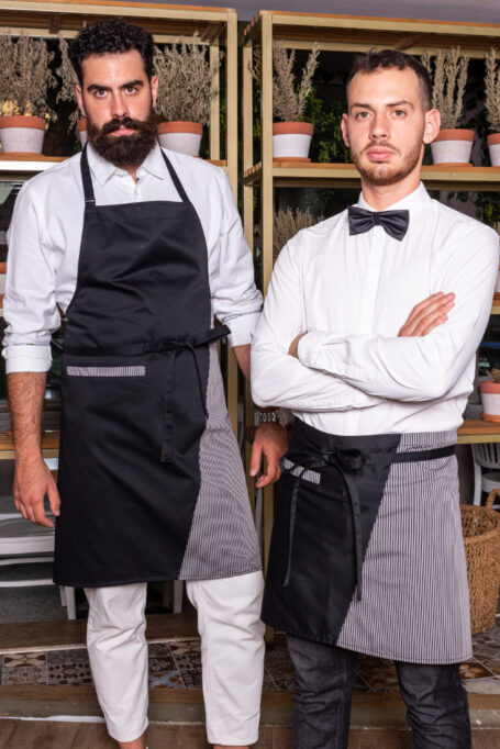 Black polycotton aprons with stylish black-gray stripes and a functional pocket. Choose from waist or neck-strap styles for a customizable and comfortable fit. Perfect for professionals and creatives in various fields. Elevate your workwear with these modern, comfortable, and versatile aprons.