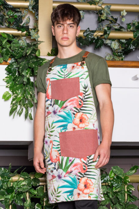 Cotton apron with tropical flamingos pattern, adjustable leather straps, and two pockets. Ideal for baristas, chefs, and various professions. Customizable with your logo.