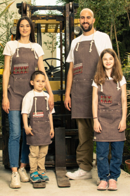 Exclusive denim apron in earth brown color, with cotton rope neck strap, pocket, ripped details and secondary boho pattern fabric for a traditional touch.