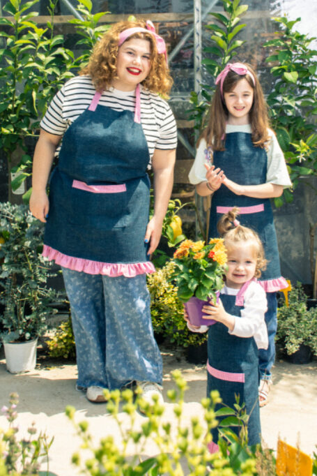 Cute & stylish cotton blue jean apron, with tied neck straps, functional pocket, secondary pink checkered cotton fabric and a matching pink ribbon.