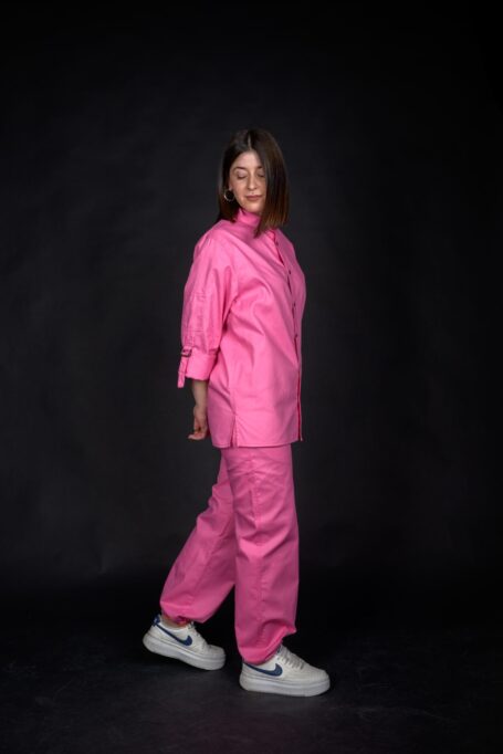 Young lady wearing a woman shirt with matching loose fit pink pants. Comfortable, durable and stylish workwear.