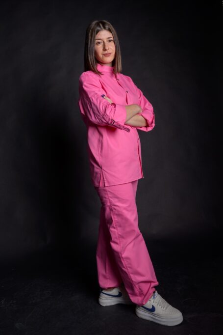 Baker wearing baggy bakery clothes. Loose fit pants and a custom shirt from medium weight durable pink fabric.