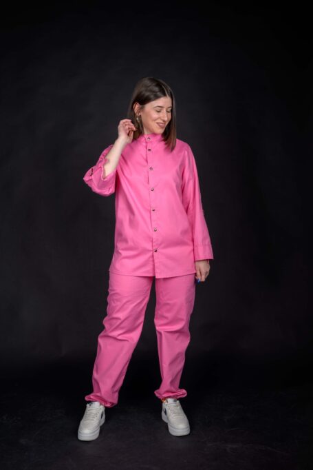 Happy woman wearing her comfortable and fashionable pink work apparel. Custom baker shirt with baby pink baggy pants.