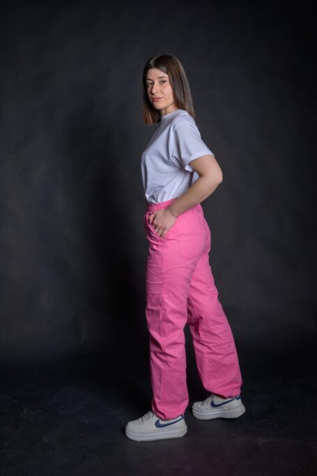 Young lady wearing street style pink pants, made from medium weight durable and breathable fabric.