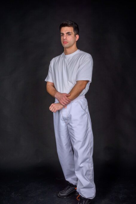 Chef wearing his comfortable white pants, made from durable and breathable white fabric, with a white t-shirt.