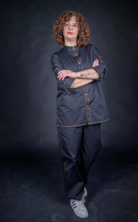 Chef wearing her beautifully designed chef clothes, with external decorative orange thread stitches.