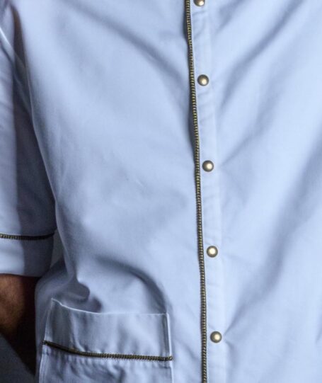 Barber shirt with metal bronze stud buttons and gold brocade on front placket, pocket and around the sleeves.
