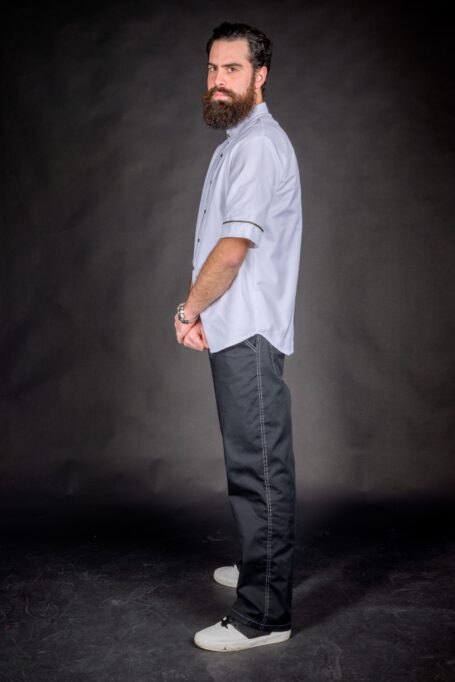 Man wearing loose fit barber clothes. Fashionable white smock with black pants.