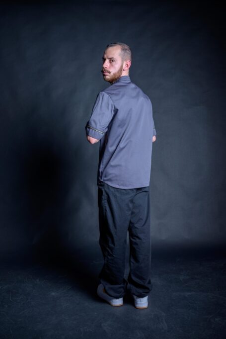 Hair stylist wearing his workwear shirt. Fashionable loose fit gray barber clothes.