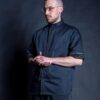 Hair stylist wearing his black workwear jacket with metal bronze stud buttons and gold brocade on front placket, pocket and around the sleeves.