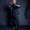 Happy man wearing a comfortable set of barber clothes in black color. Barber smock with matching baggy pants.