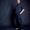 Fashionable black barber smock and pants. Man feeling comfortable and happy while wearing them.