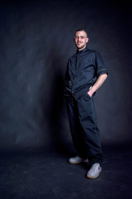 Fashionable black barber smock and pants. Man feeling comfortable and happy while wearing them.