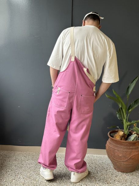 Woman wearing a fashionable unisex streetwear salopette with two back pockets and adjustable elastic ankle cuffs.