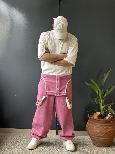 Man wearing loose fit overall pants, made from heavy weight durable cotton fabric.