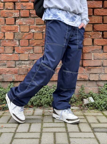 Blue loose fit pants styled with white sneakers and casual sweatshirt.